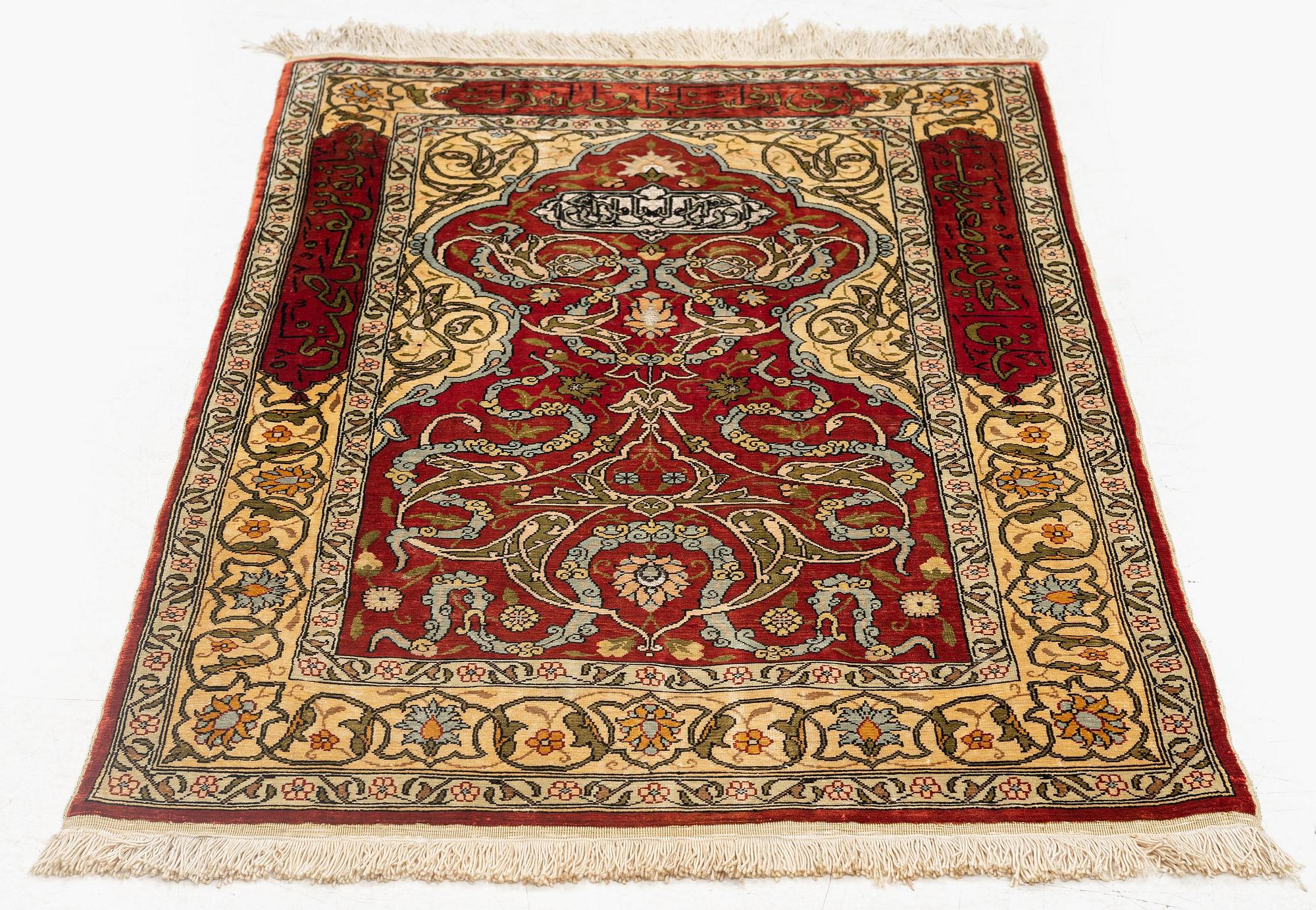 A silk and metal Hereke rug, c. 86 x 52 cm.