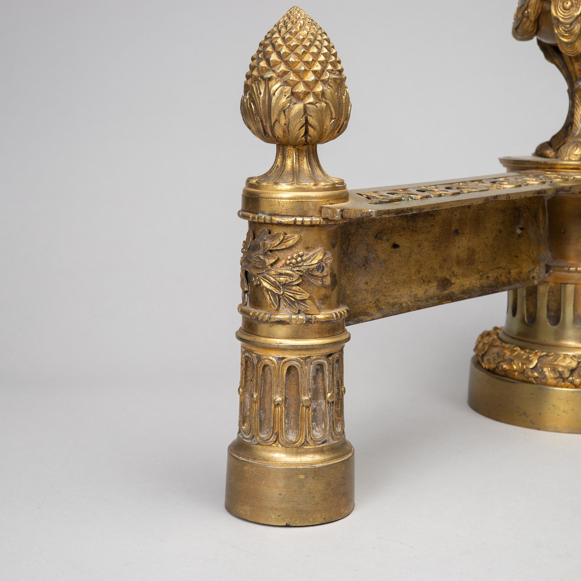 A pair of gilt brass Louis-XVI style andirons, second half of the 19th Century.
