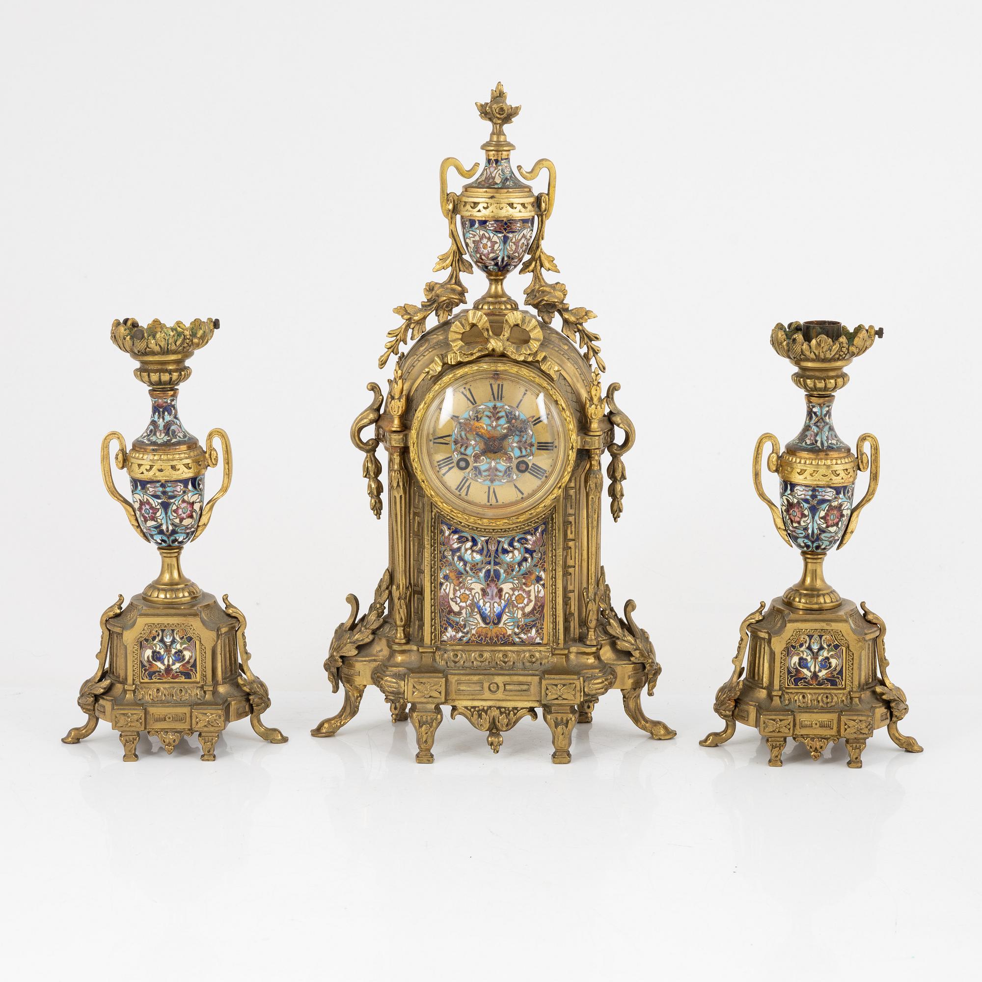 A set of two Louis XVI-style candle sticks and a mantle clock, late 19th century.