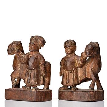 A pair of wooden sculptures of a man with a horse, Qing dynasty, circa 1900.