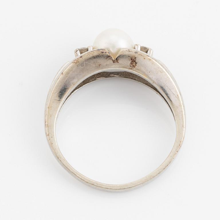 Ring med pärla och två briljantslipade diamanter.