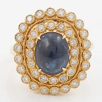 Ring in 18K gold set with a cabochon-cut sapphire and brilliant-cut diamonds.