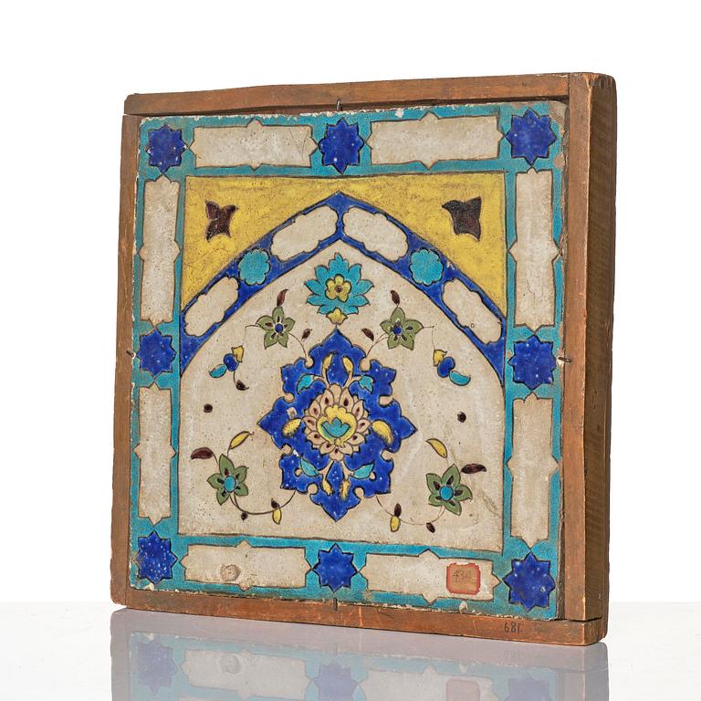 A 'cuerda seca' pottery tile, c. 39 x 40 cm (with mounting 44 x 44 cm), Persia (Iran), the Qajar dynasty (1789–1925).