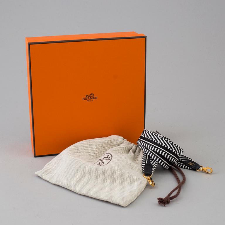 A bag strap by Hermès.