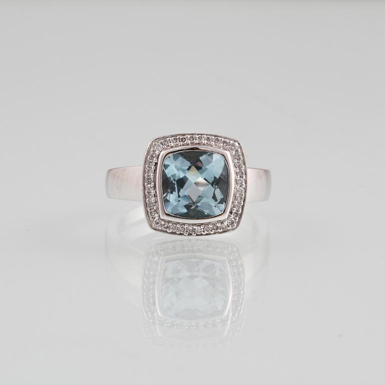 RING, 18K vitguld med fasettslipad blå topas samt 36 briljantslipade diamanter, ca 0.18 ct. Vikt 8,2 gram.