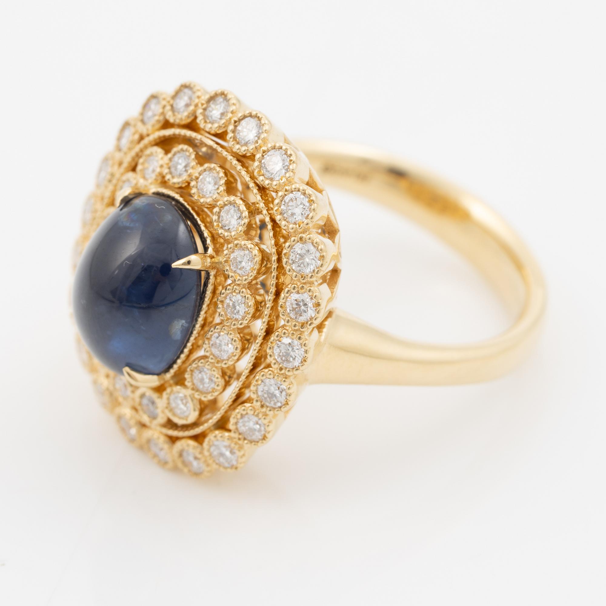 Ring in 18K gold set with a cabochon-cut sapphire and brilliant-cut diamonds.