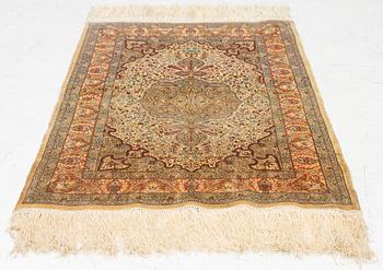 A silk Hereke rug, c. 85 x 55 cm.