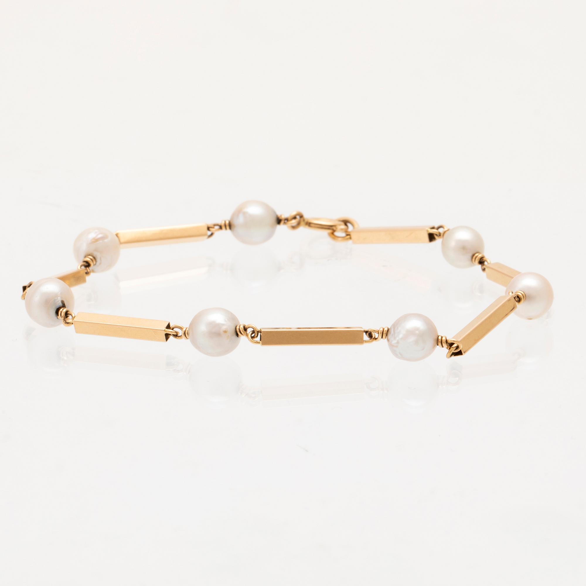 An 18K gold bracelet set with cultured pearls.