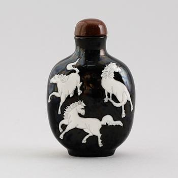 An enamelled porcelain snuff bottle with stopper, Qing dynasty (1644-1912).