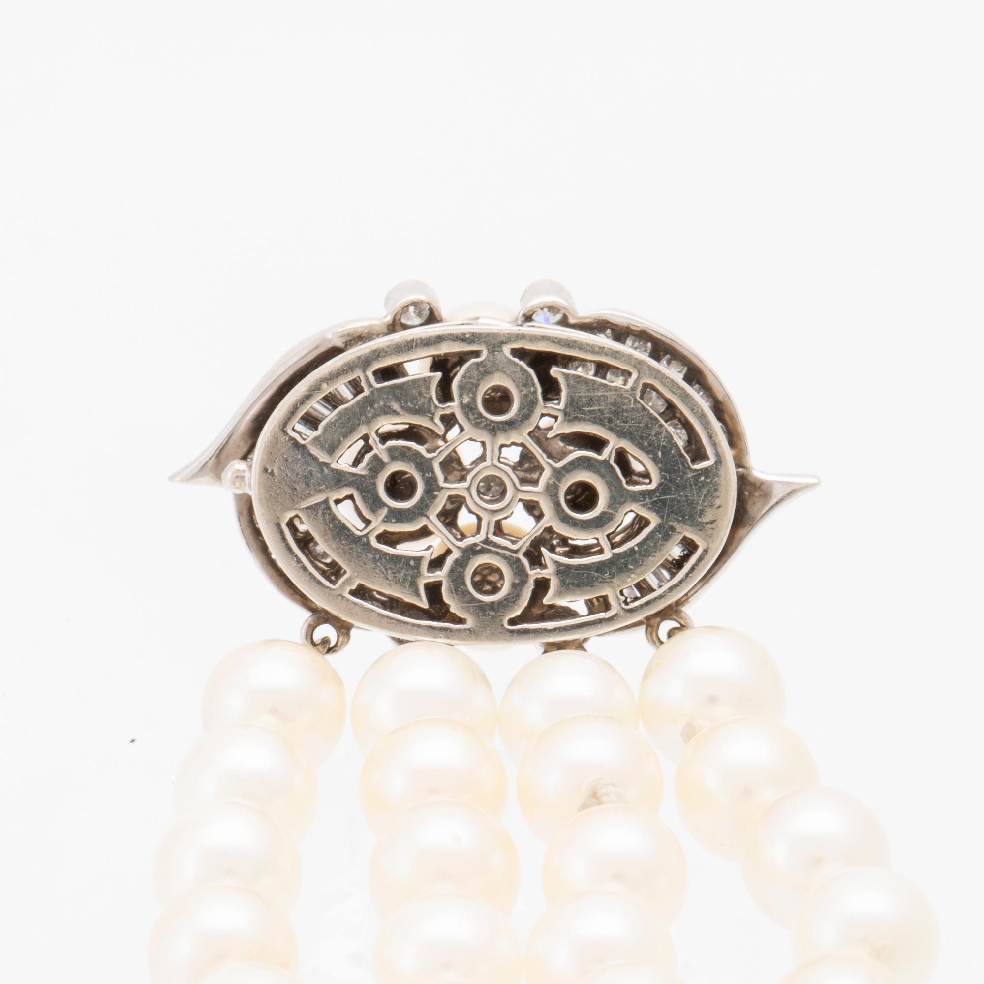 Armband 4-radigt med odlade pärlor, runda briljantslipade samt baguettslipade diamanter och lås i 14K vitguld.
