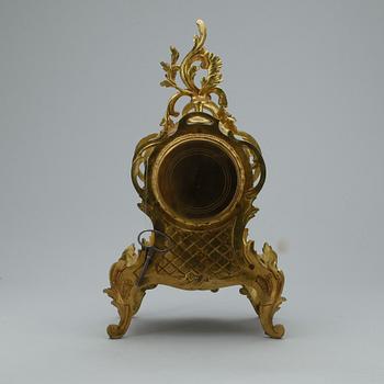 GARNITYR MED BORDSPENDYL OCH ett par KANDELABRAR, mässing, Louis XV-stil, troligen omkring 1900.