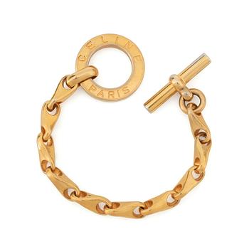 CÈLINE, a gold coloured bracelet.