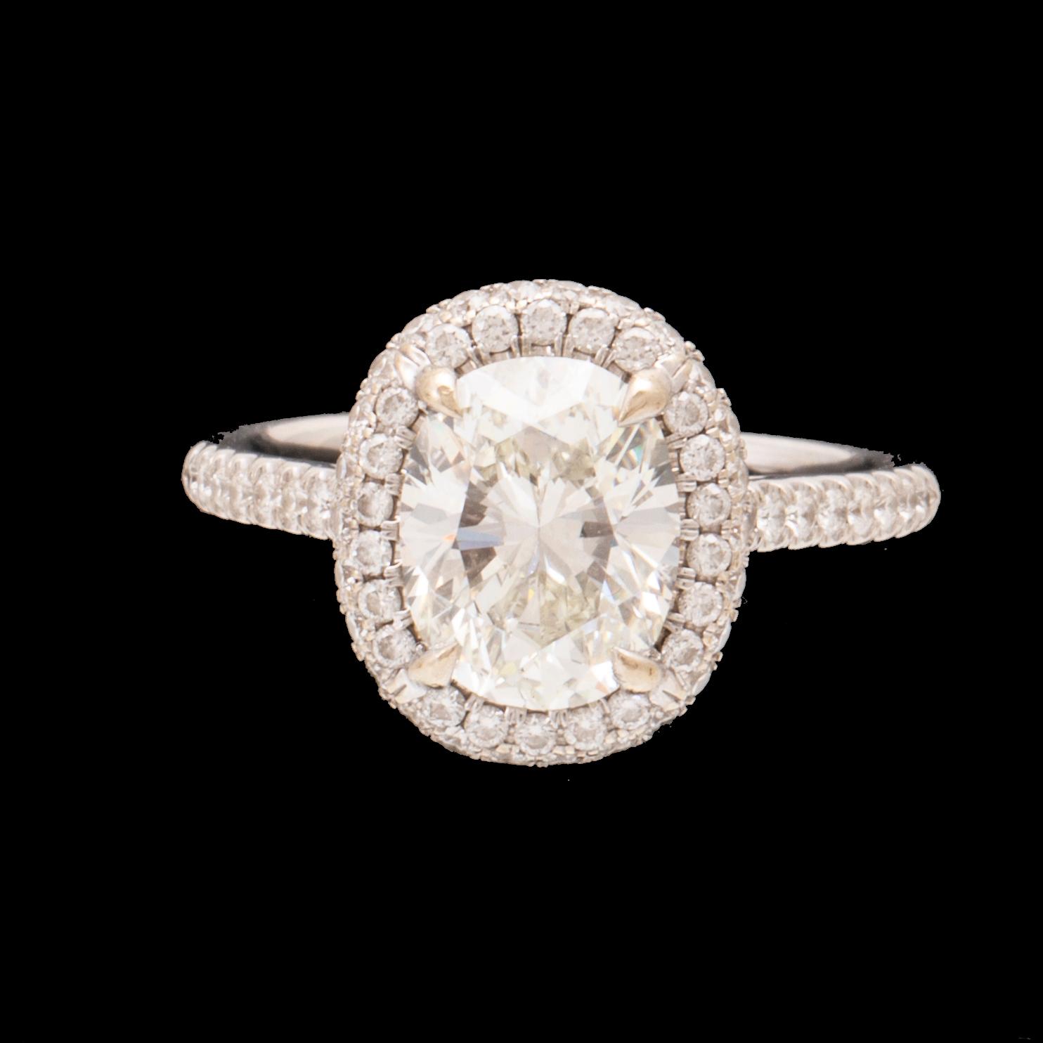 An 18K white gold ring by James Allen, set with an oval brilliant cut diamond in a halo of round brilliant cut diamonds.