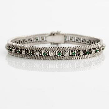 Bracelet 18K gold with round brilliant-cut diamonds and green stones, likely emeralds.