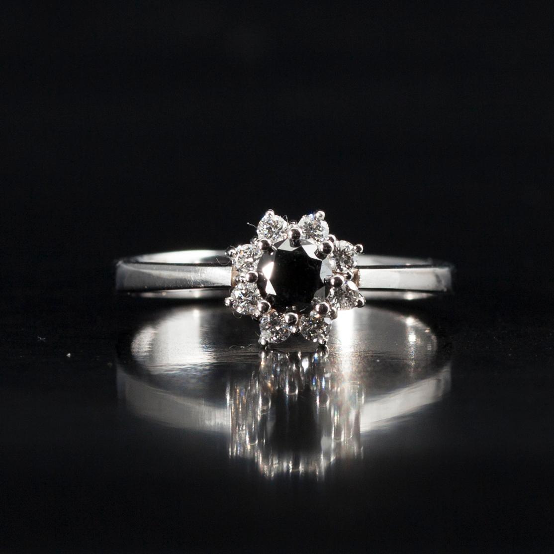 RING, vitguld 14K, briljantslipade diamanter. Mittstenen svartfärgad diamant 0,38 ct, 8 sidostenar tot. 0,18 ct. Intyg.