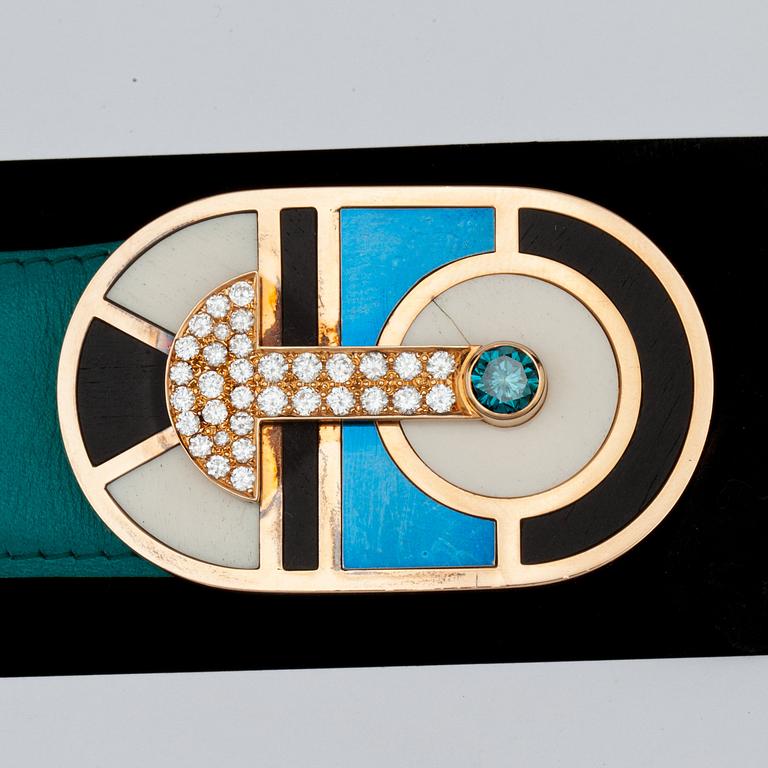 A gold and diamond belt buckle, tot. app. 1.50 cts white diamonds and app. 0.65 cts treated blue diamond.