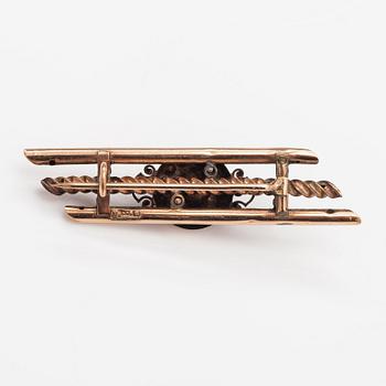 A 14K gold brooch with pearls and garnet glass doublet.