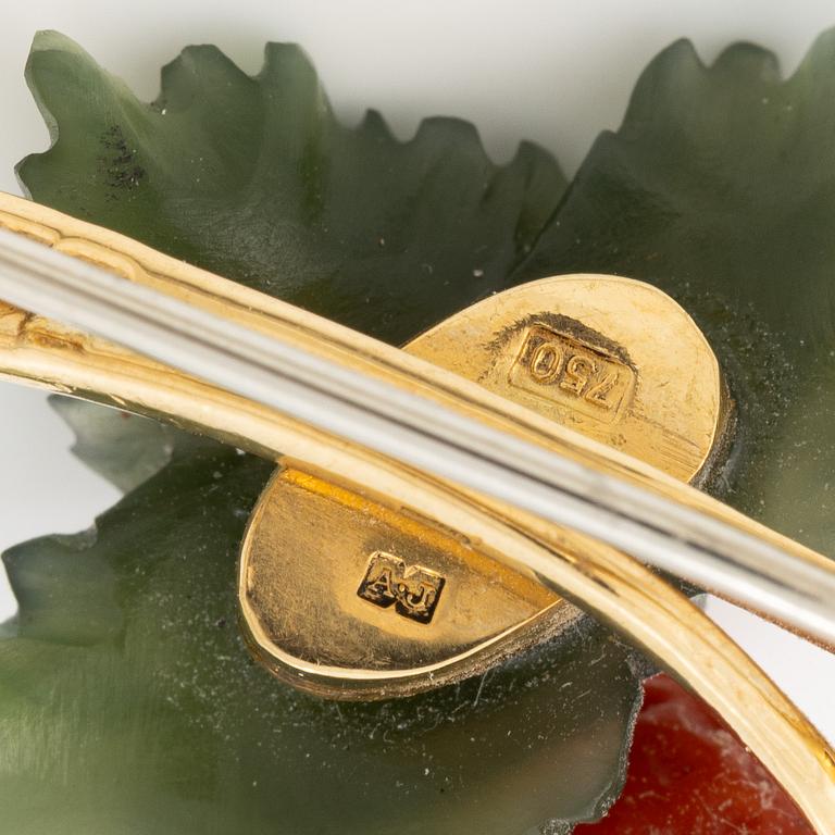 A flower brooch 18K gold with coral, rock crystal, a green stone likely nephrite, and a round brilliant-cut diamond.