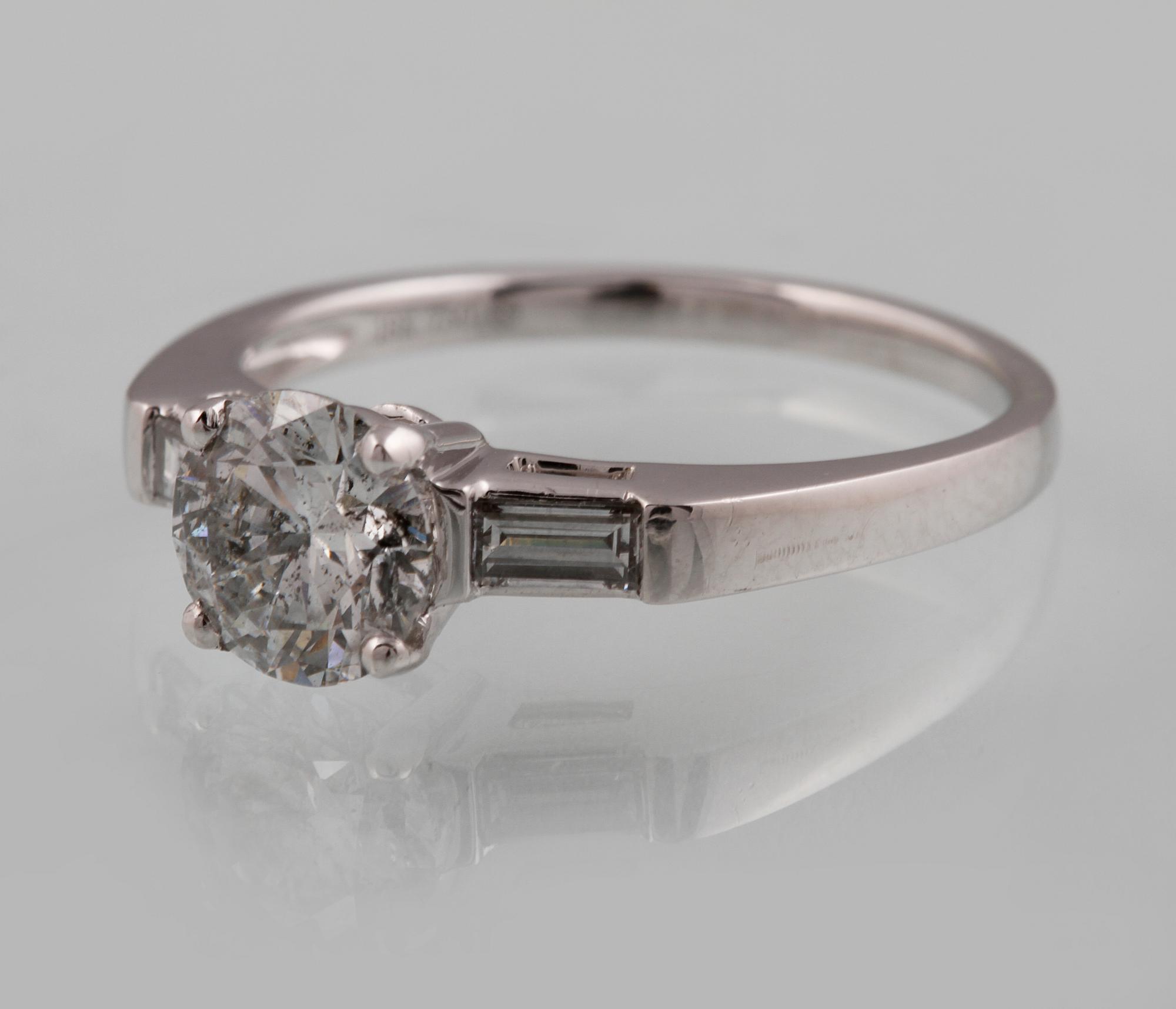 RING, 18K vitguld med briljantslipad diamant ca 1.05 ct samt 2 baguettslipade diamanter ca 0.17 ct. Vikt 3,2 gram.