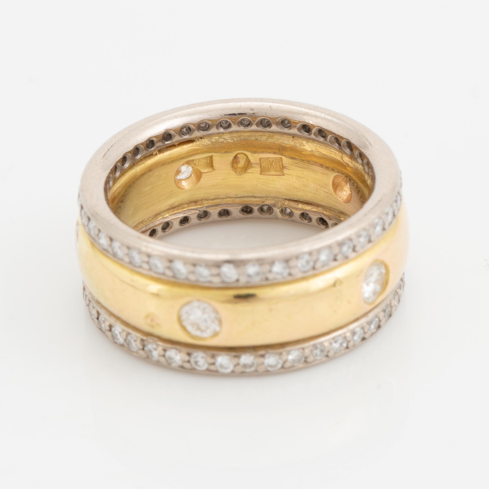 An 18K gold ring set with round brilliant-cut diamonds.