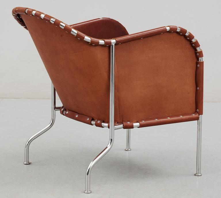 A Mats Theselius steel and brown leather easy chair.