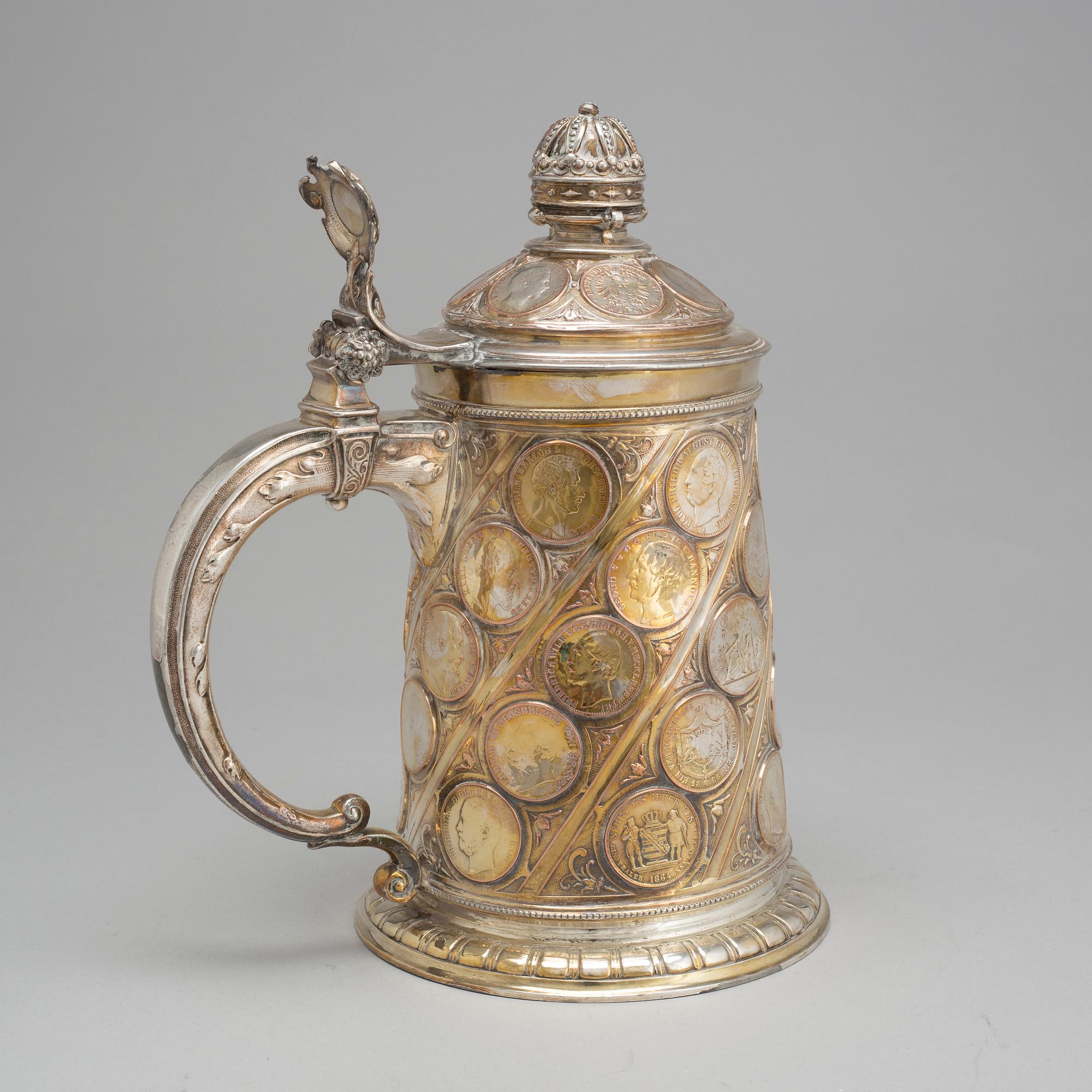 A late 19th century EPNS tankard with silver coins.