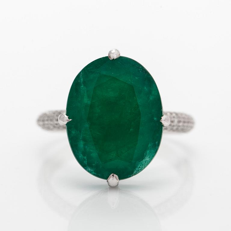 A 14K white gold ring, set with an oval-cut emerald and diamonds. Accompanied with IGI certificate.