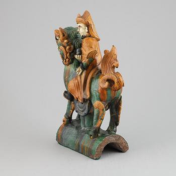 A Chinese sancai glazed stoneware roof tile in the form of a dignitary on a buddhist lion,  Mingdynasty (1368-1644).