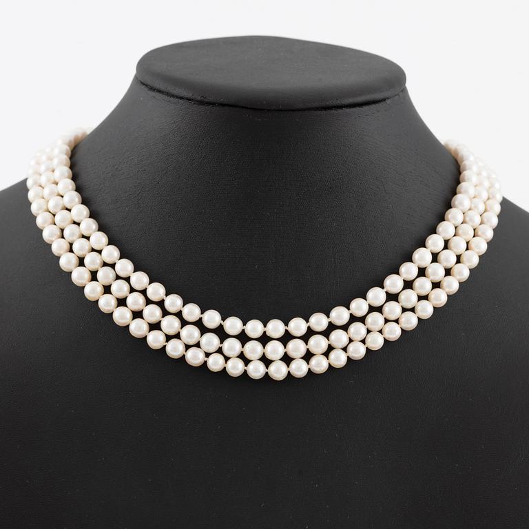 Pearl necklace, three strands of cultured pearls, clasp in 18K gold set with baguette and brilliant-cut diamonds.