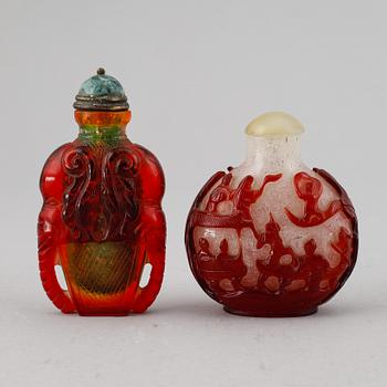 A set of two peking glass snuff bottles with stoppers, Qing dynasty, 20th Century.