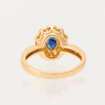 An 18K gold ring set with an oval faceted sapphire and round brilliant-cut diamonds.