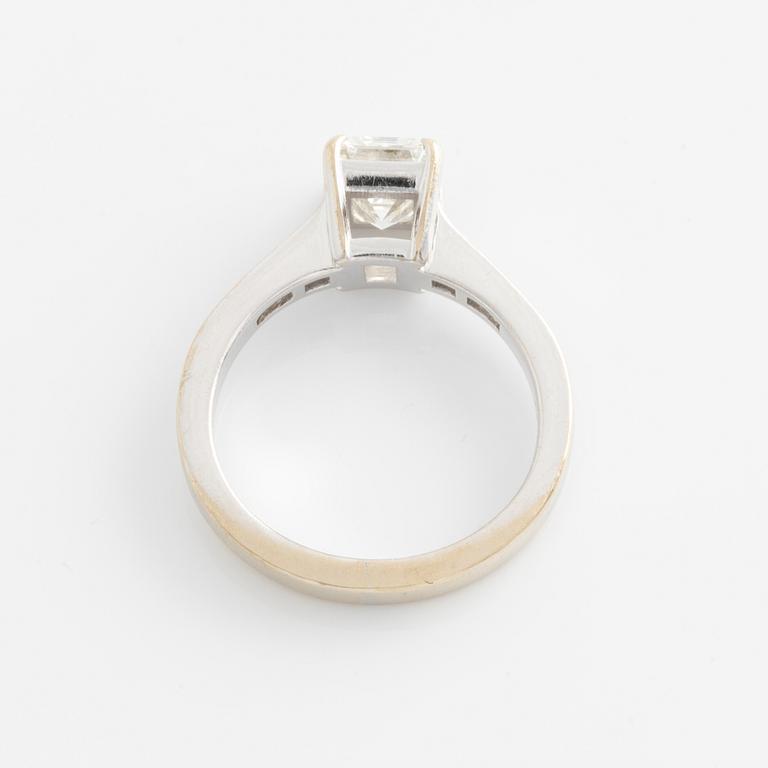 An 18K white gold ring set with an emerald-cut diamond.