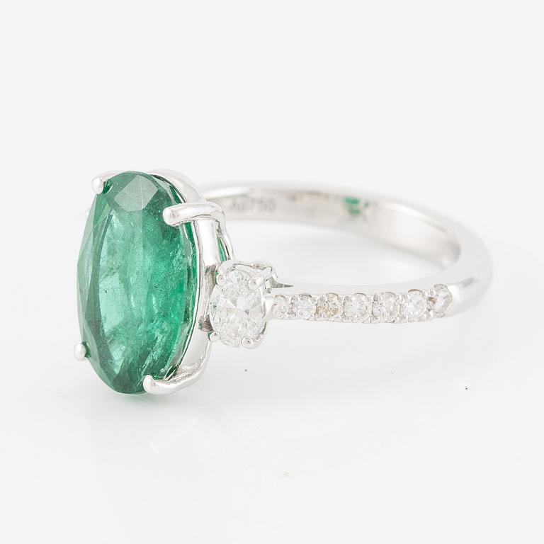 Ring in 18K white gold with an oval emerald and oval-cut and brilliant-cut diamonds.