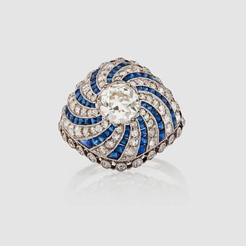 1129. A 'spinning wheel' sapphire and diamond ring. Circa 1930. French hallmarks. Platinum. Size 16.50/52. Weight circa 5 g.