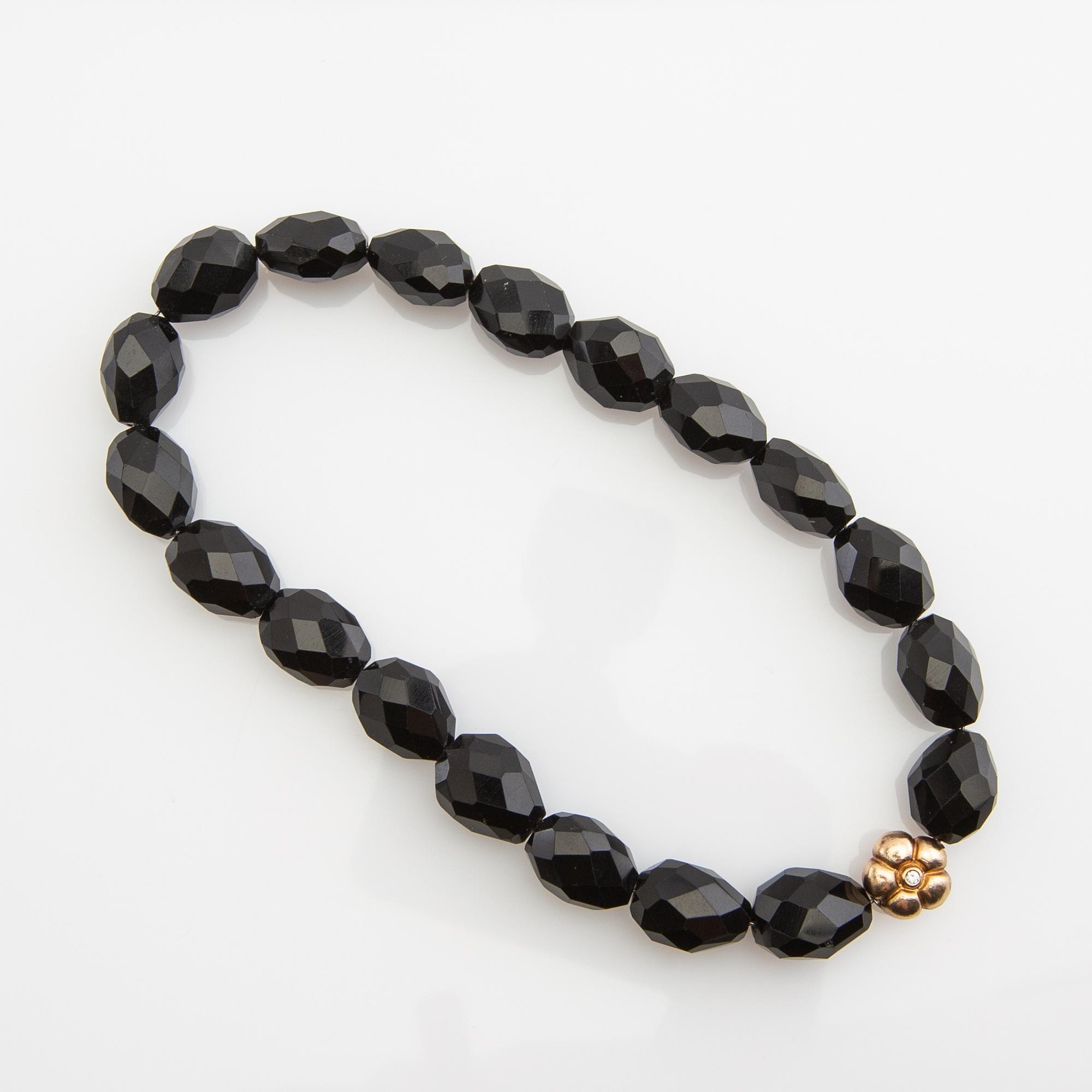 Ole Lynggaard, clasp, 18K gold with a round brilliant-cut diamond, and two necklaces.