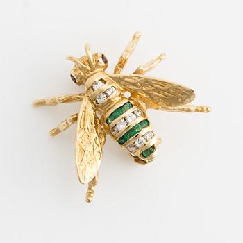 Brooch 18K gold set with round faceted emeralds and rubies, as well as round brilliant-cut diamonds.