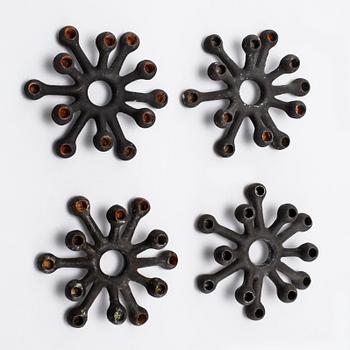 Four 1960s iron cast candle holders, designed by Jens Quistgaard for Dansk Designs .