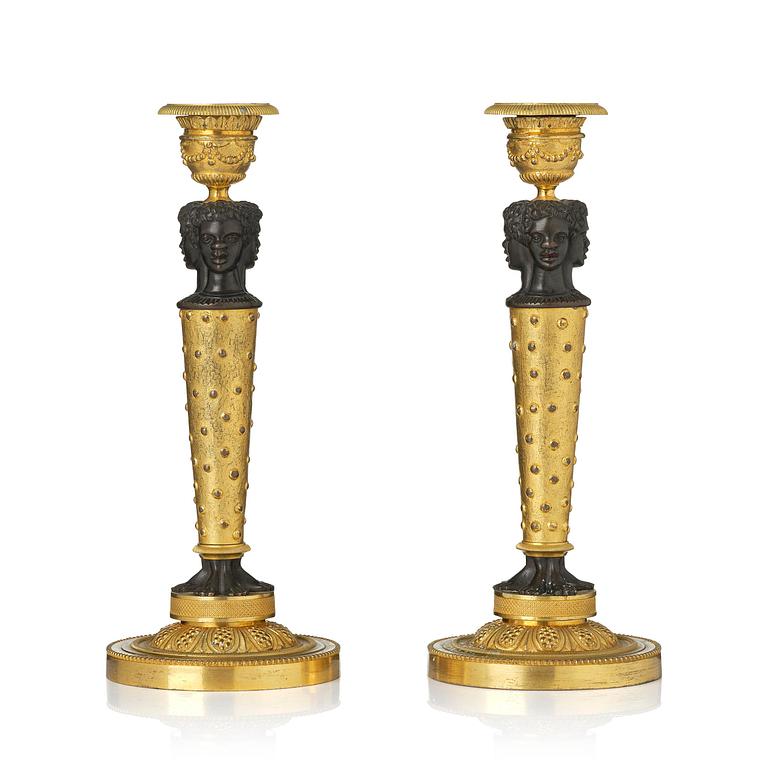 A pair of Napoleon III gilt and patinated bronze candlesticks, later part 19th century.