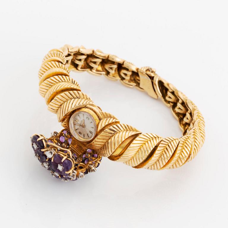 A Gübelin bracelet/wristwatch in 18K gold set with amethysts and round brilliant-cut diamonds.