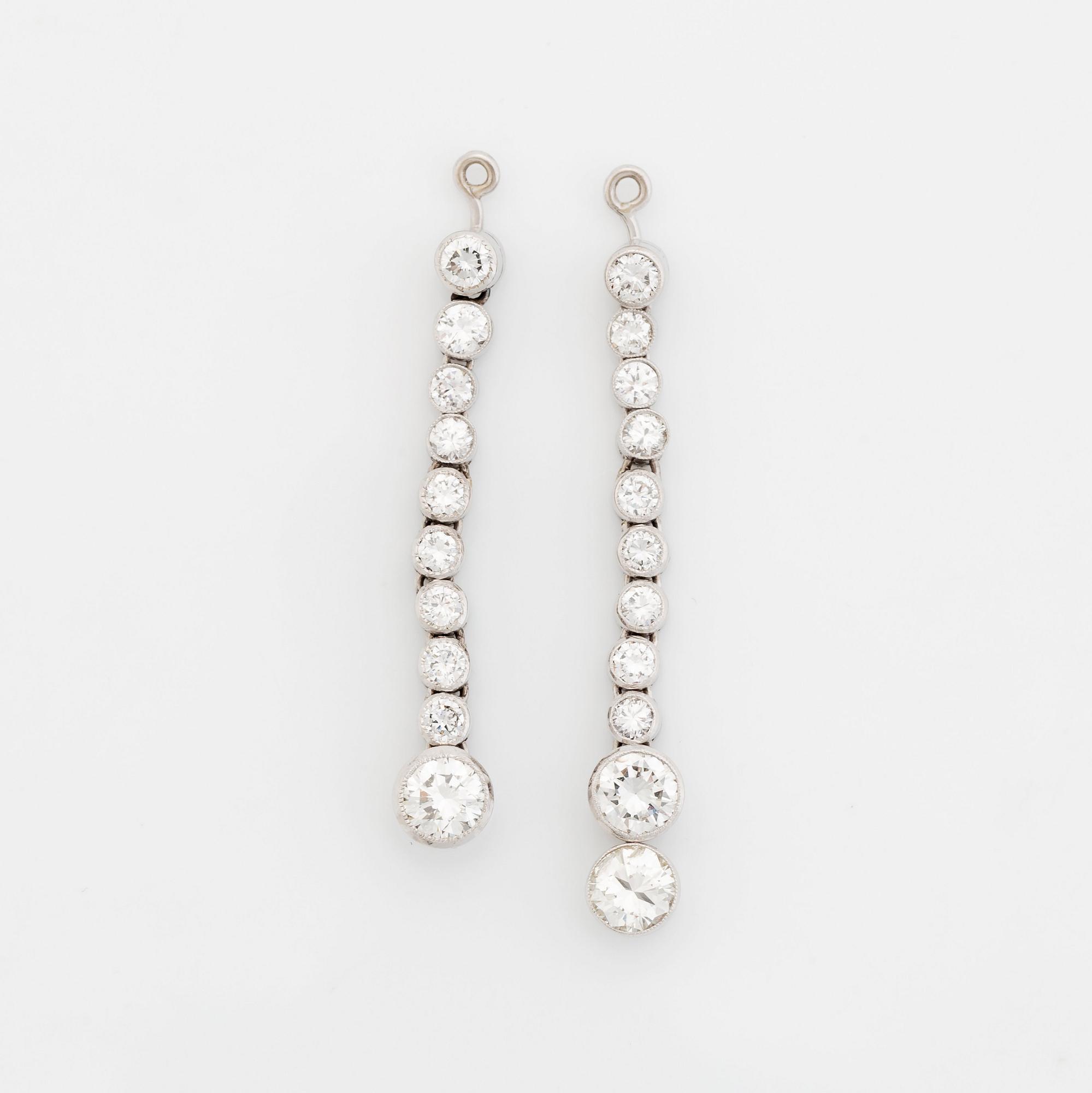 A pair of 18K white gold earrings set with round brilliant-cut diamonds.