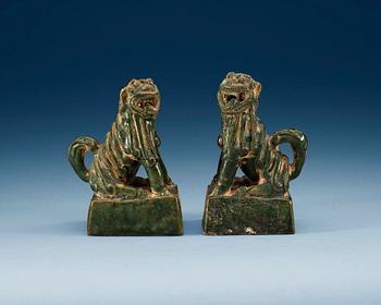 1658. A pair of green glazed figures of 'Buddhist Lions', Ming dynasty.