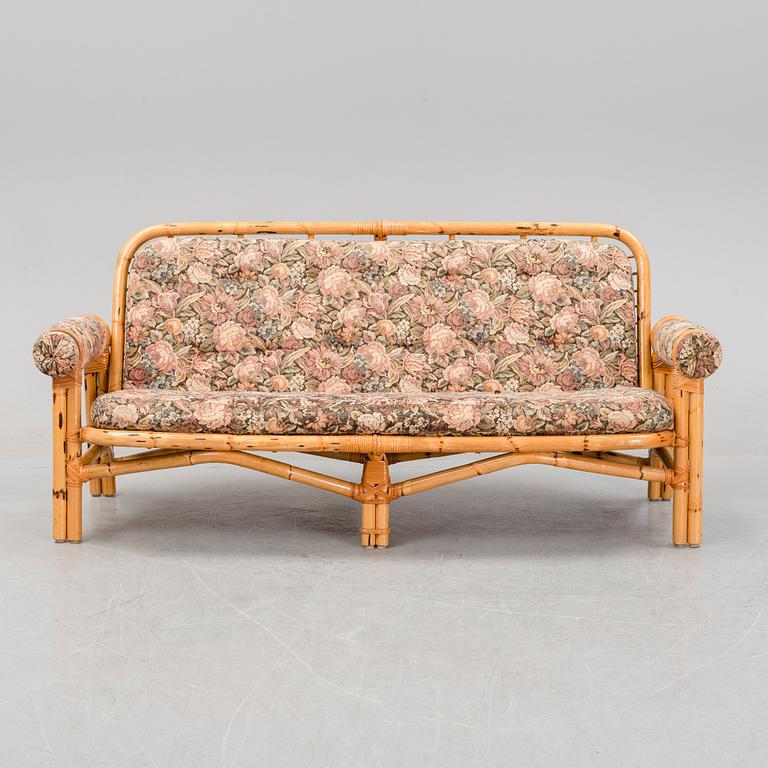 A set of two garden sofas, an armchair and a glass table, later part of the 20th Century.