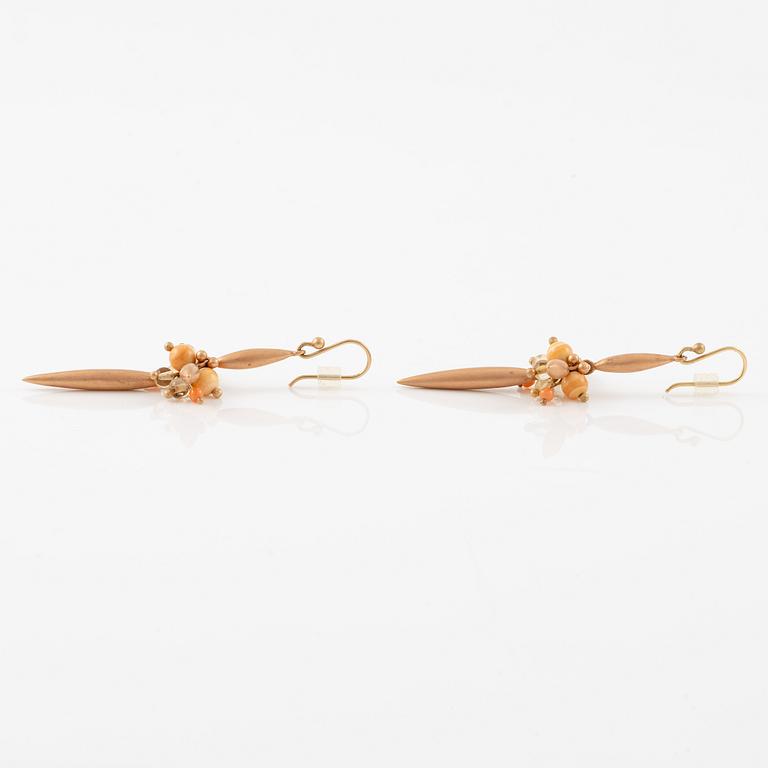 A pair of earrings in 14K and 9K gold with coral and quartz, by Ted Muehling purchased at Svenskt Tenn.
