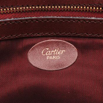 A set of two 1970s bordeaux leather handbags by Cartier.