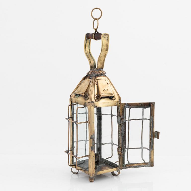 A metal storm lantern, marked A.T, circa 1900.