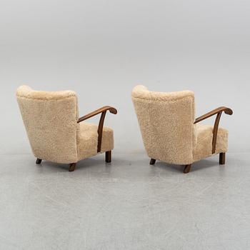 A pair of Danish lounge chairs with sheepskin upholstery.