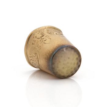 An 18K gold thimble.