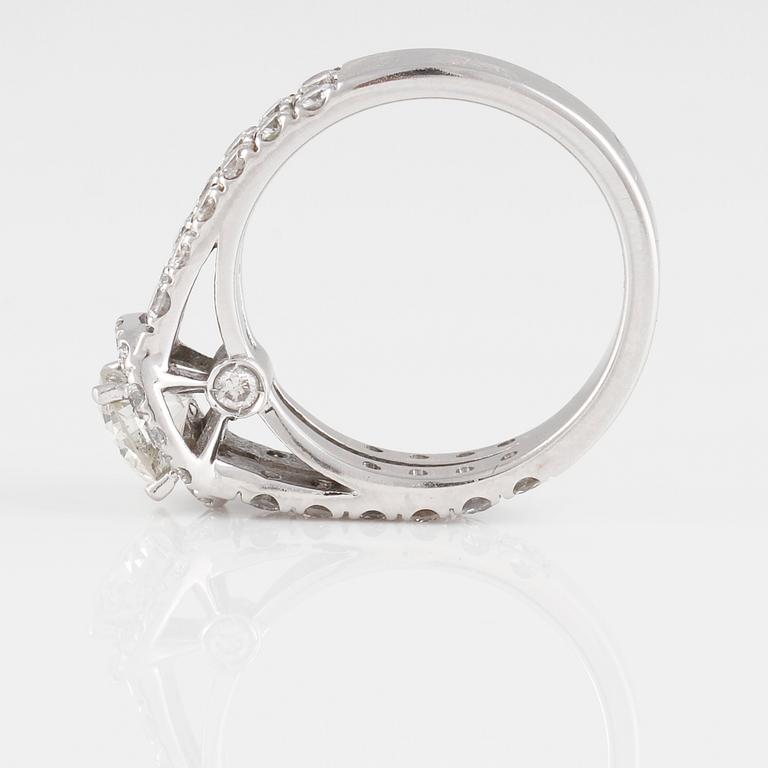 RING, 18K vitguld med briljantslipad diamant ca 0.80 ct samt små briljantslipade diamanter ca 6.30 ct. Vikt 6,3 gram.