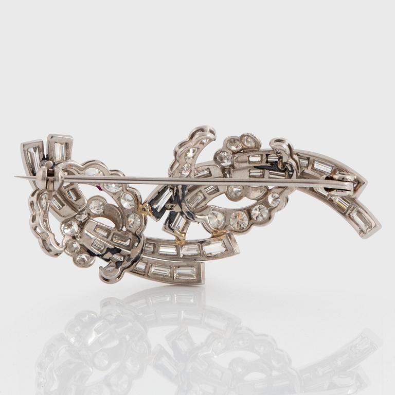 A platinum brooch set with baguette- and round brilliant-cut diamonds.