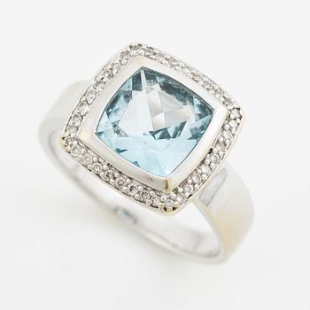 Ring 18K vitguld med en fasettslipad topas och runda briljantslipade diamanter.